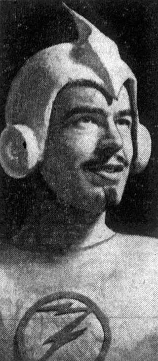Black and white image of a person in a superhero costume with a helmet and circular emblems on the chest with a z in it